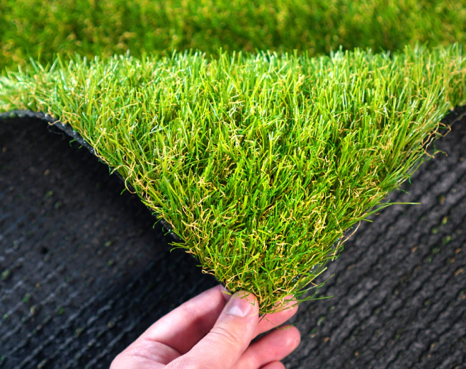 hand holding an artificial grass roll